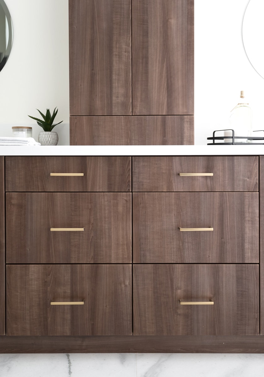 A warm brown Contemporary vanity with several drawers and gold hardware.