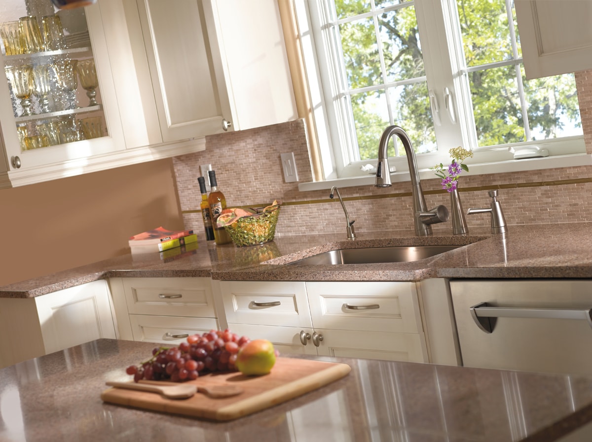 Bright, netural toned kitchen with sunlight pouring through a large window.