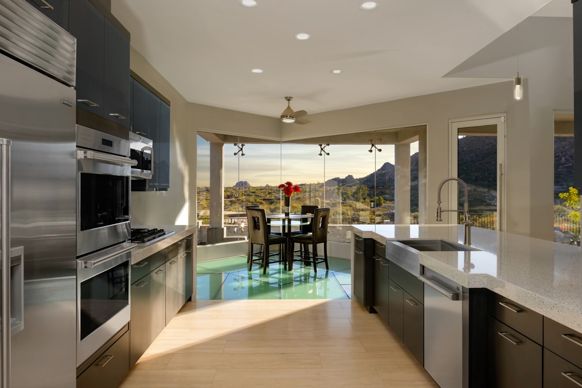 A Contemporary kitchen with large windows and bright sunlight.