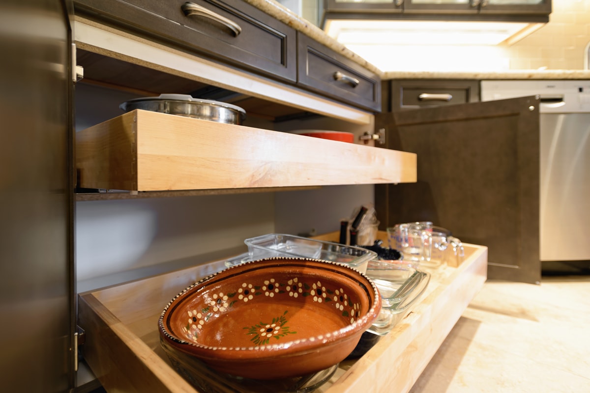 Two pulled out kitchen drawers with dishes.