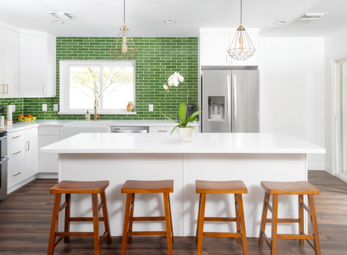 White kitchen island with four bar stools.