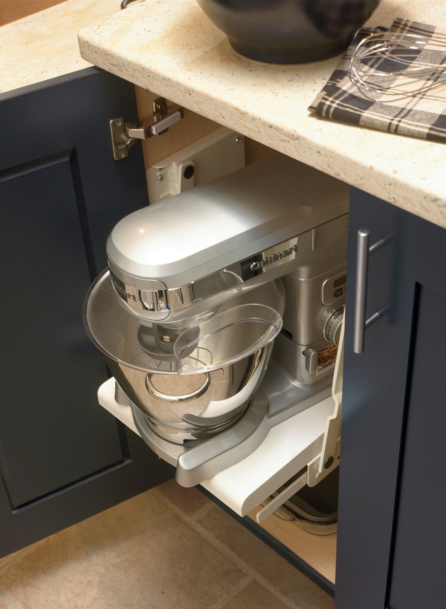 An open navy blue cabinet door with a shelf holding a mixer.