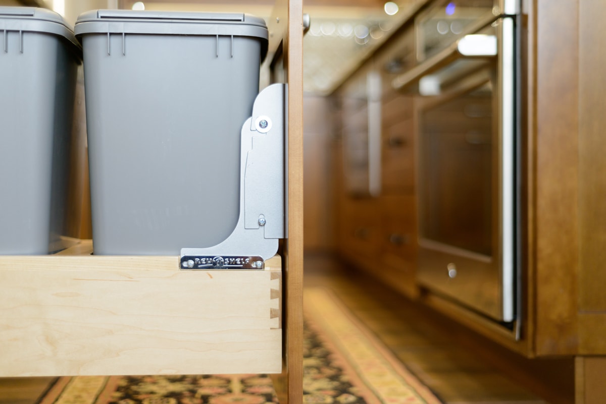 A large pull-out cabinet with two recycling bins.