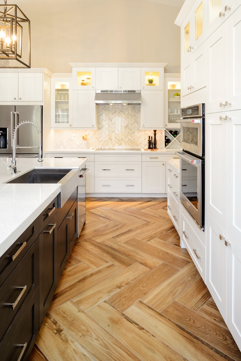 A kitchen with a mixture of white shaker-style cabinetry and cabinets with glass inserts.