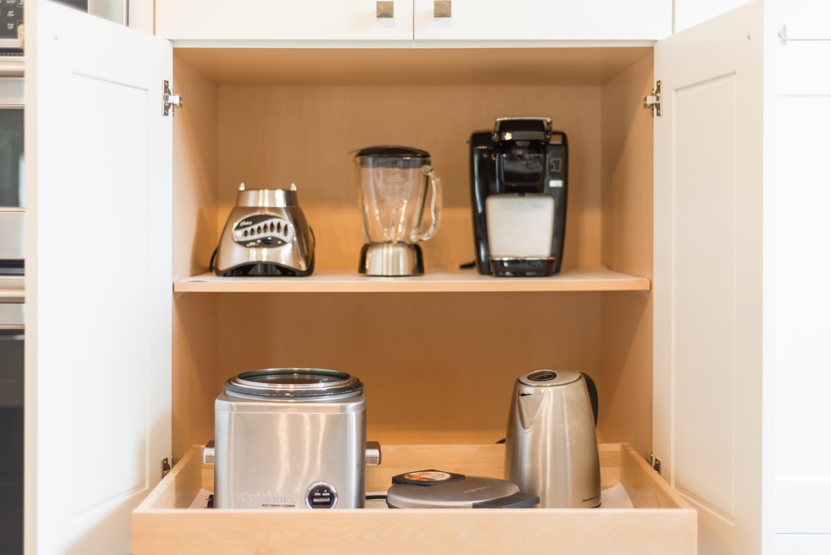 An open cabinet with two shelves, the bottom shelf is rolled out.