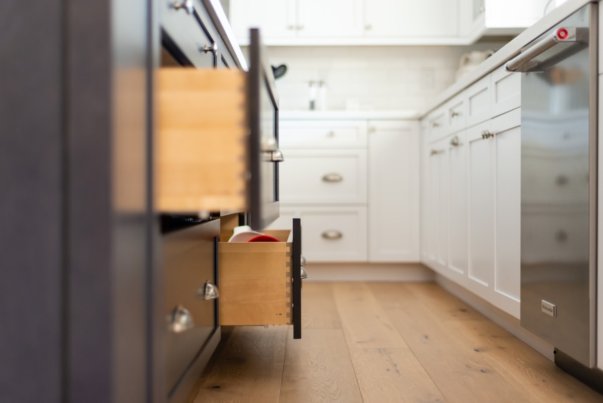 Dark brown kitchen island with two drawers pulled out slightly.